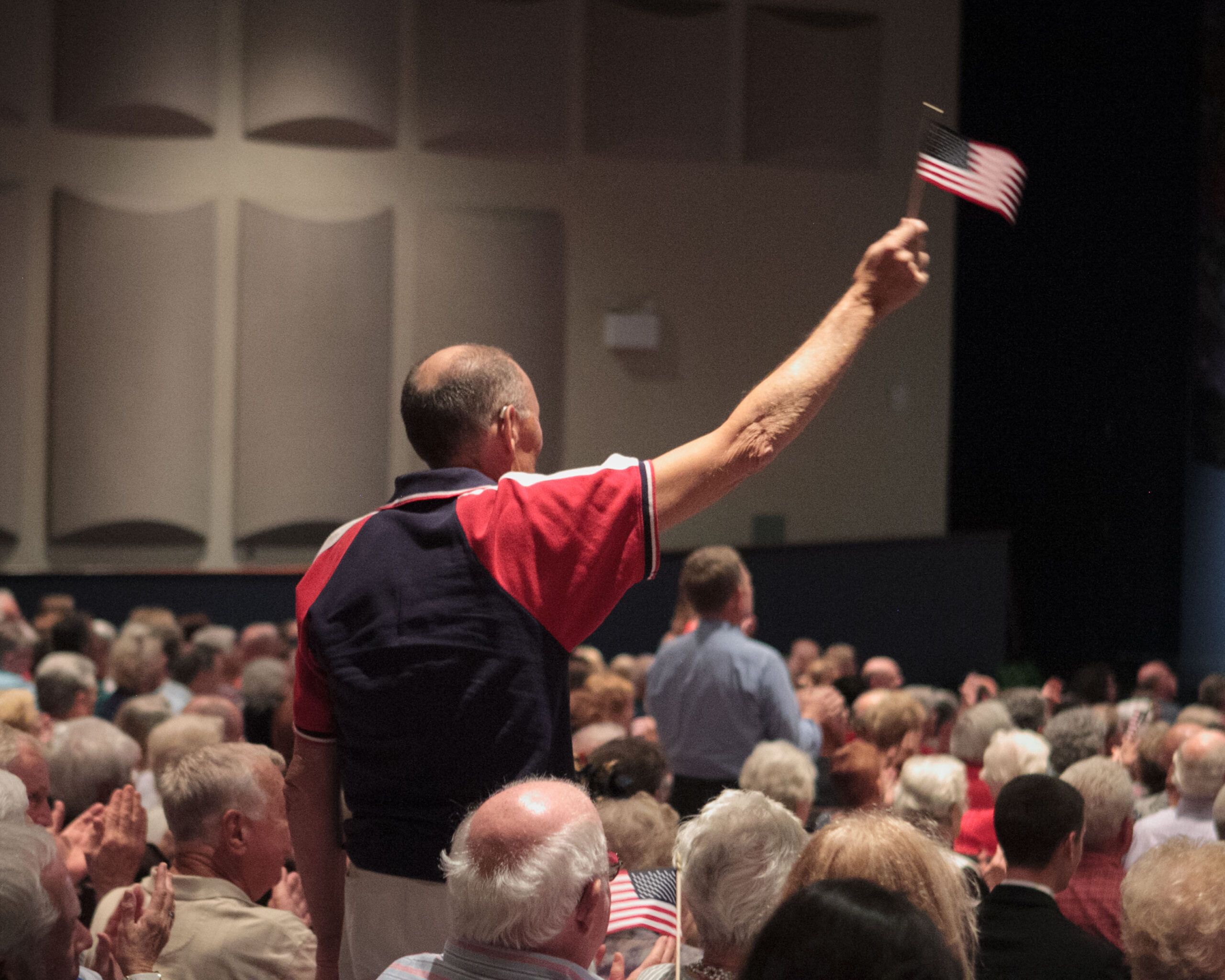 A man waves the flag at a Space Coast Symphony patriotic concert